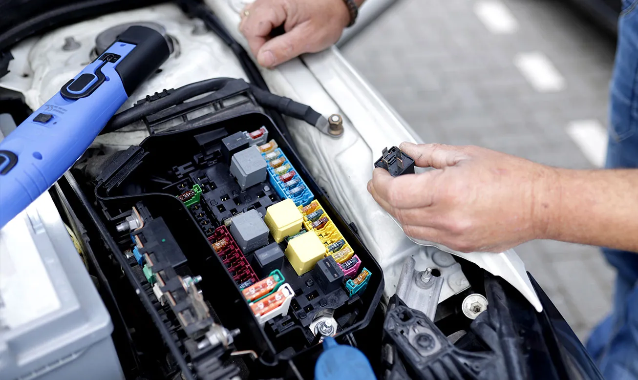 Technician working on a car's electrics
